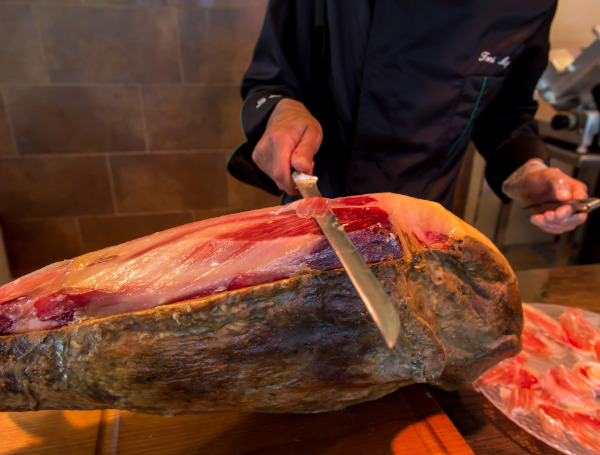 Un chef qui découpe des lamelles de jamon ibérico