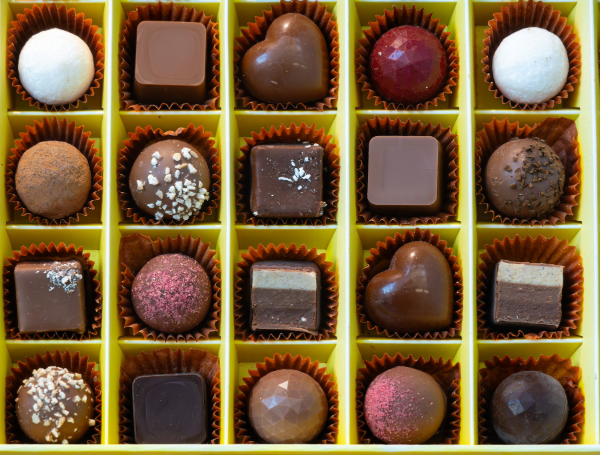 Assortiment de pralines au chocolat suisse gastronomiques dans une boîte jaune
