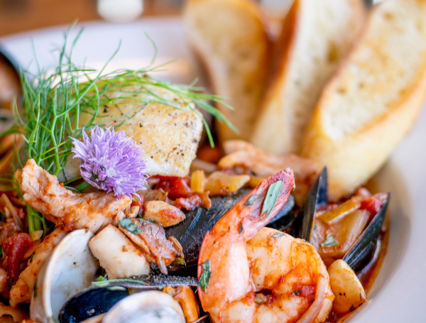 Gros plan sur une bouillabaisse aux fruits de mer avec crevettes, moules, palourdes, poisson, fenouil et pain grillé