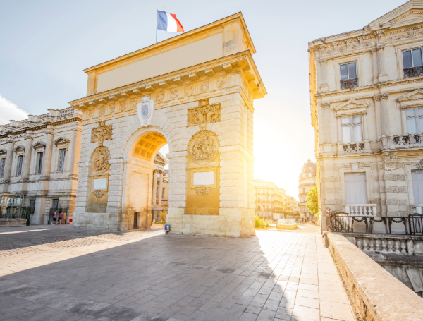Vue de rue avec l'Arc de Triomphe au lever du soleil à Montpellier, en Occitanie (France)